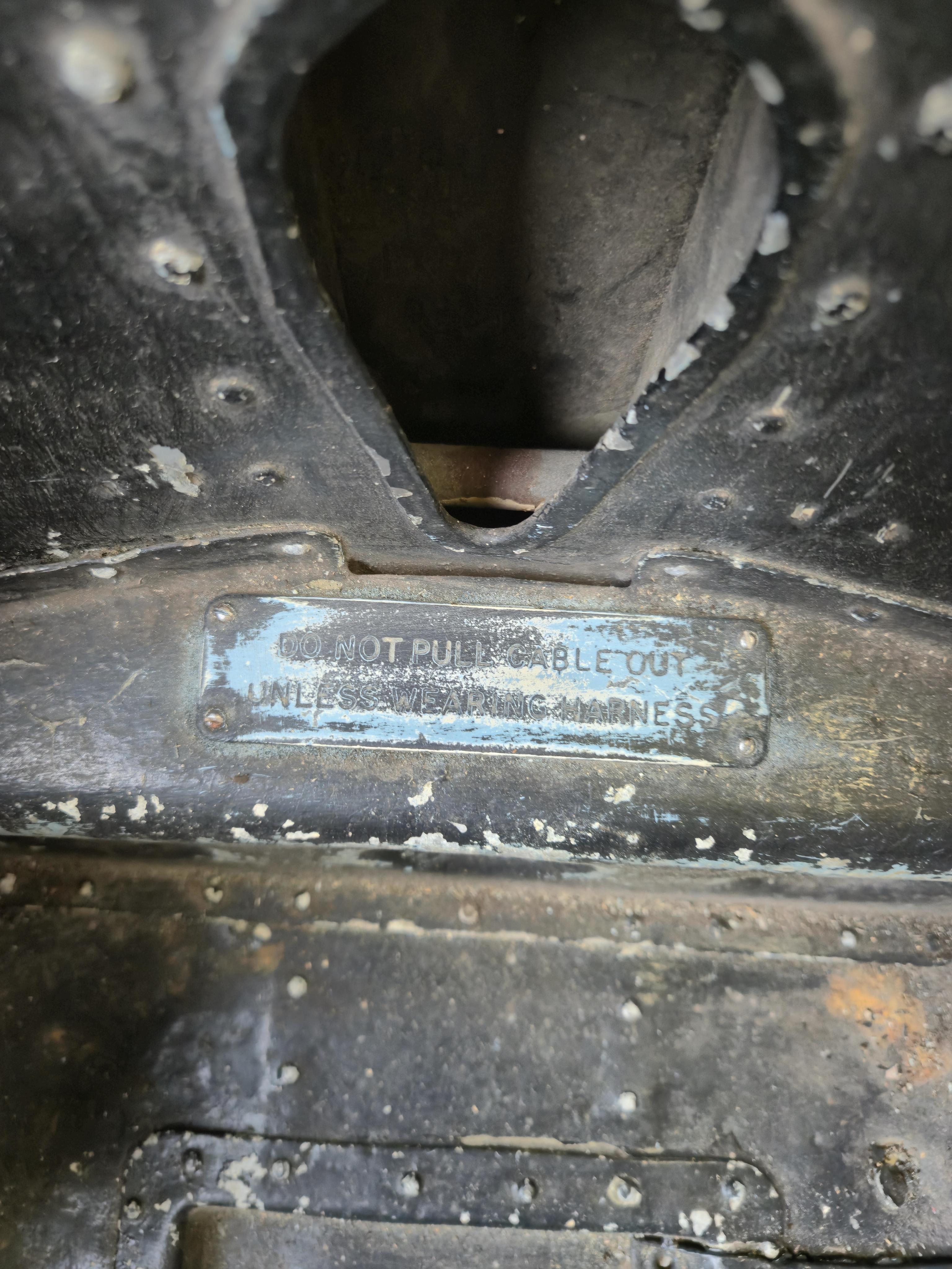 A WWII bomber navigator's chair, with painted aluminium bucket seat and pedestal stand, with a later wooden base, height without base 84cm, the width across the arms 59cm